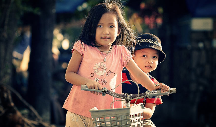 two kids on a bike back to school