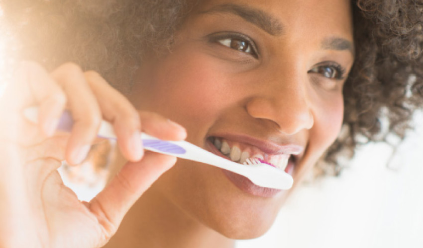 young woman brushing her teeth