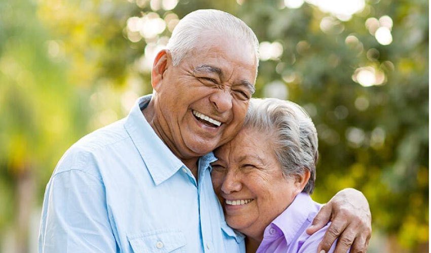 senior couple hugging and smiling after oral health exams