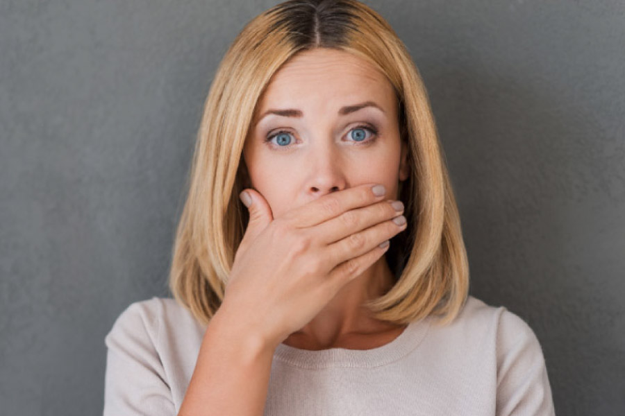 woman covering her mouth with her hand to hide early gum disease