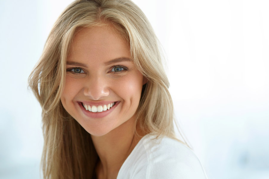 young woman flashes a brilliant smiles after professional teeth whitening