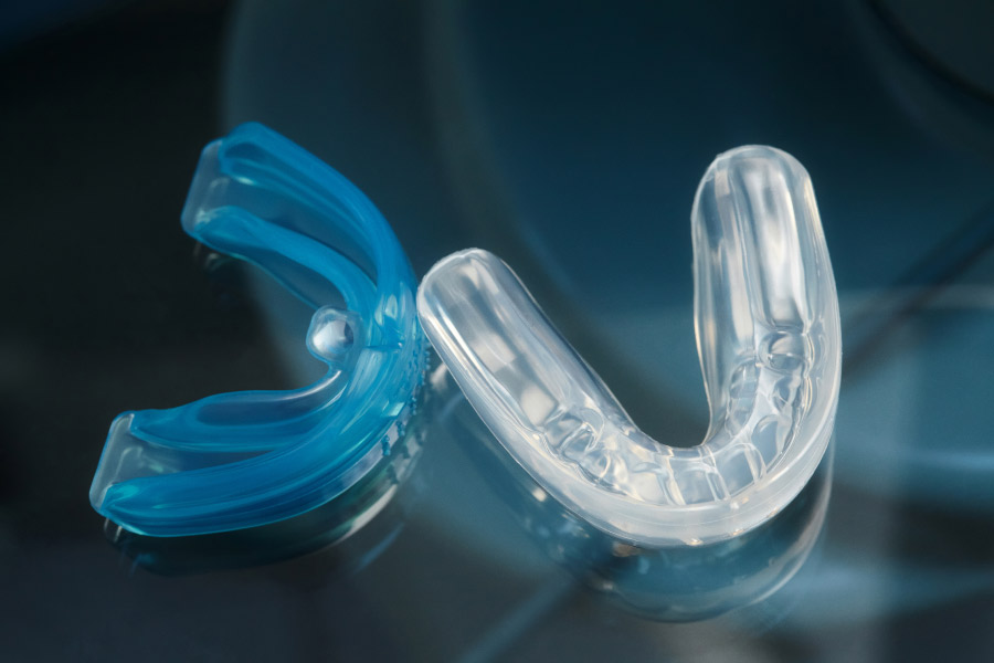 two mouthguards, one blue, the other clear