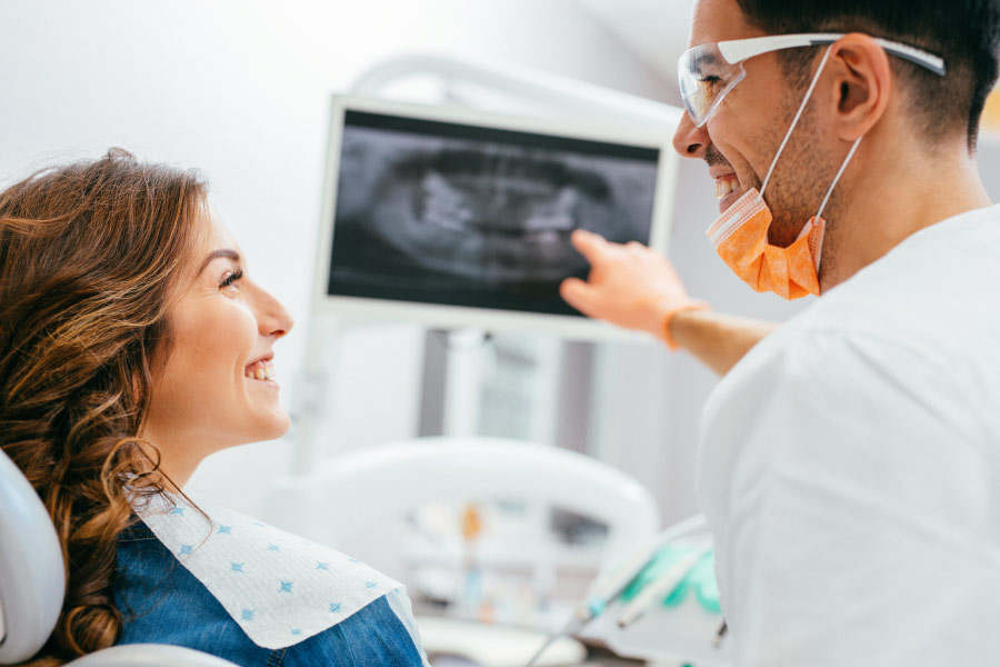 woman looks at her dental x-rays with the dentist