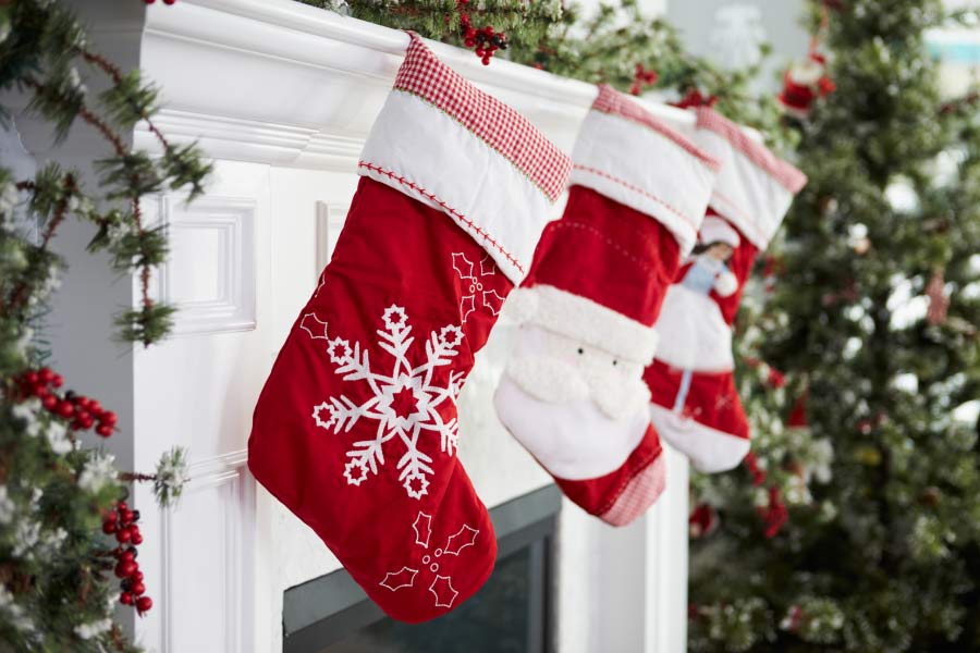 three Christmas socks hanging on the mantle