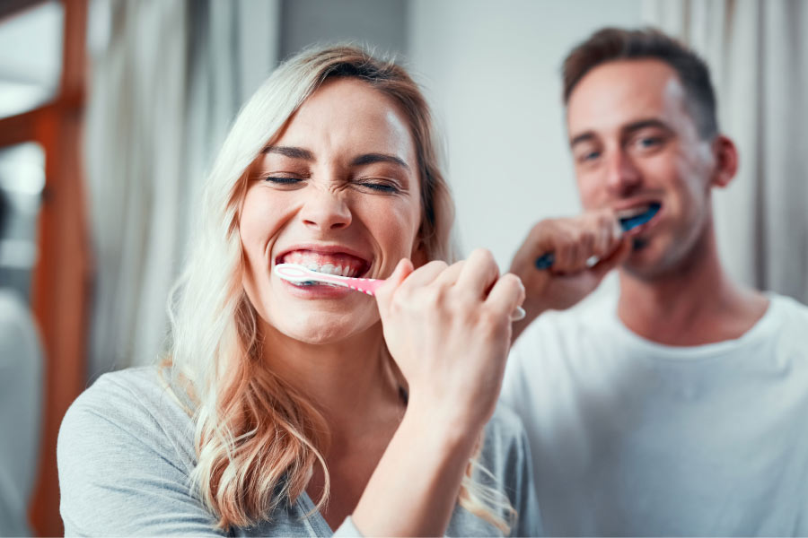 young couple brush their teeth together