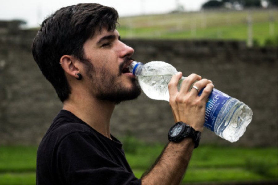 man drinking a big bottle of water