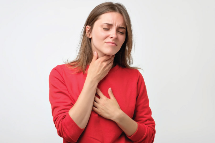 woman suffering from allergies holds her throat and chest