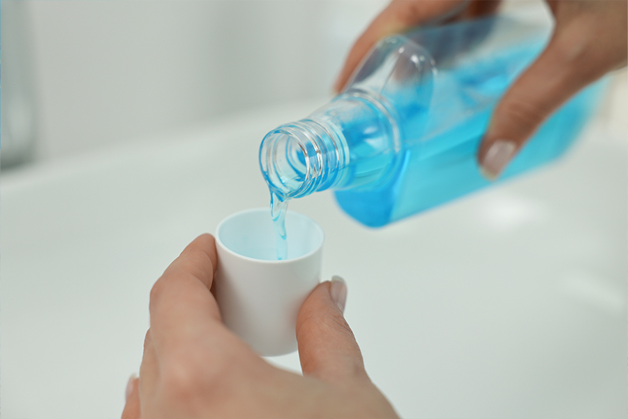 mouthwash being poured into a small cup